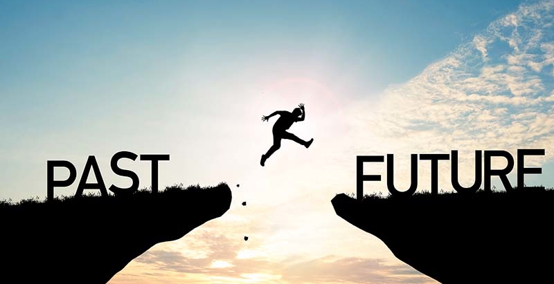 An image of a man leaping from a cliff labeled 'past' to one labeled 'future,' symbolizing the blog's theme on starting the New Year with a clean slate and offering tips to get organized.